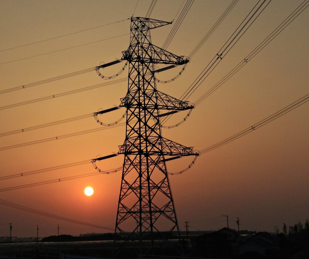 Torre de energía eléctrica de alto voltaje al amanecer.